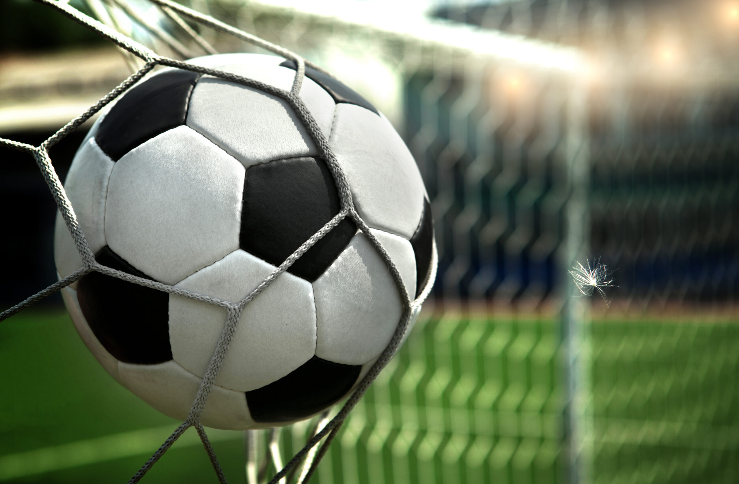 A footbaall ball slammed into the net from close